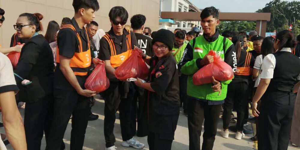 Karyawan First Club bersama Bhabinkamtibmas dan pengurus RT/RW menyalurkan paket sembako Kemerdekaan RI ke-81 kepada pengemudi ojol dan warga.