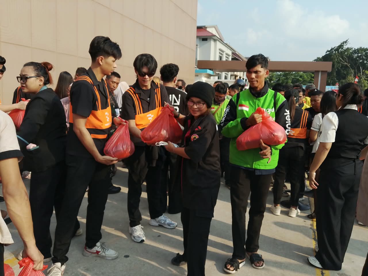 Karyawan First Club bersama Bhabinkamtibmas dan pengurus RT/RW menyalurkan paket sembako Kemerdekaan RI ke-81 kepada pengemudi ojol dan warga.